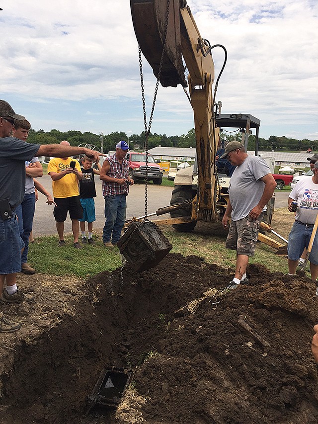 The time capsule buried by the 100th Moniteau County Fair board in 1966 was uncovered and found to be water-logged. One of the first items pulled from the time capsule was a pistol in its holster.