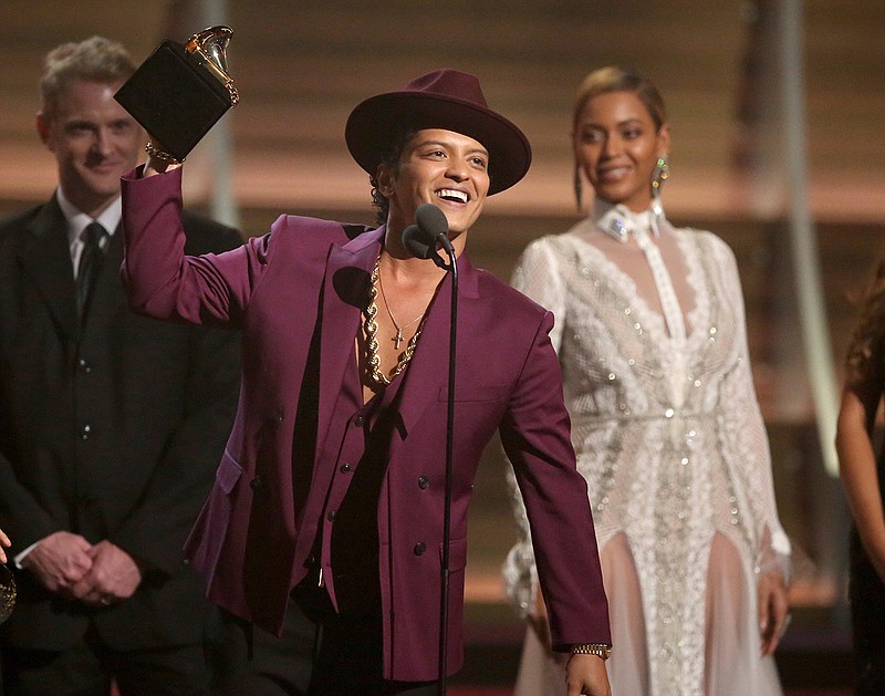 In this Feb. 15, 2016 file photo, Bruno Mars accepts the award for record of the year for "Uptown Funk" at the 58th annual Grammy Awards in Los Angeles. The Grammy-winning star said in an interview with The Associated Press he wrote "24K Magic" around the time "Uptown Funk" topped the Billboard Hot 100 chart last year. "24K Magic" debuted at No. 5 on the Hot 100 chart this week. 
