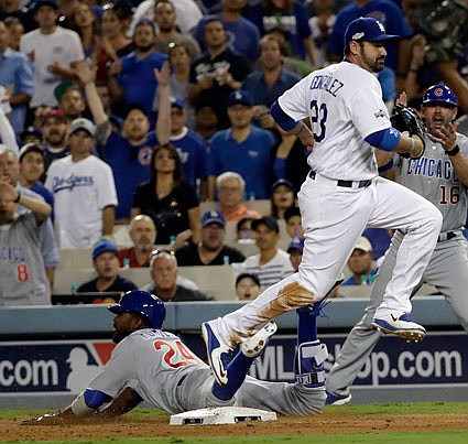 Dexter Fowler of the Cubs slides safely to first in front of Adrian Gonzalez of the Dodgers during the eighth inning of Thursday night's game in Los Angeles.