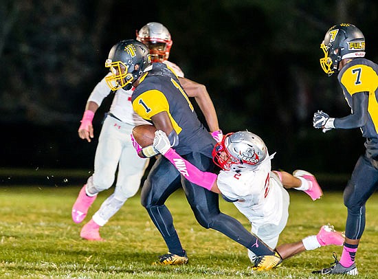 Fulton wide receiver L'Trevion Vaughn tries to escape the grasp of Mexico strong safety Cameron Holman during a game earlier this month in Fulton.