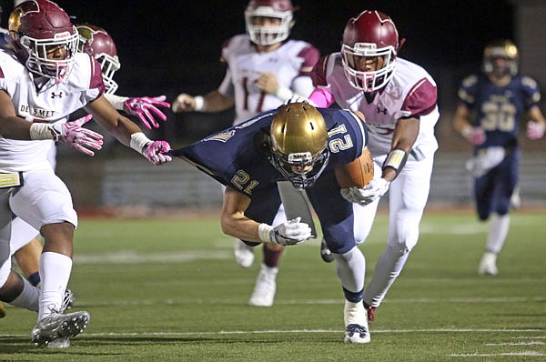 Jacob Storms of Helias tries to break away from the grasp of a DeSmet tackler during last Saturday night's game at Adkins Stadium.