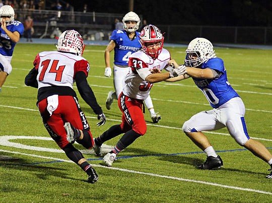 Carson Ridgeway (middle) of Jefferson City blocks Ty Simsheuser (right) of Rockhurst while Adam Huff (left) of Jefferson City returns a kickoff during last Friday night's game in Kansas City.