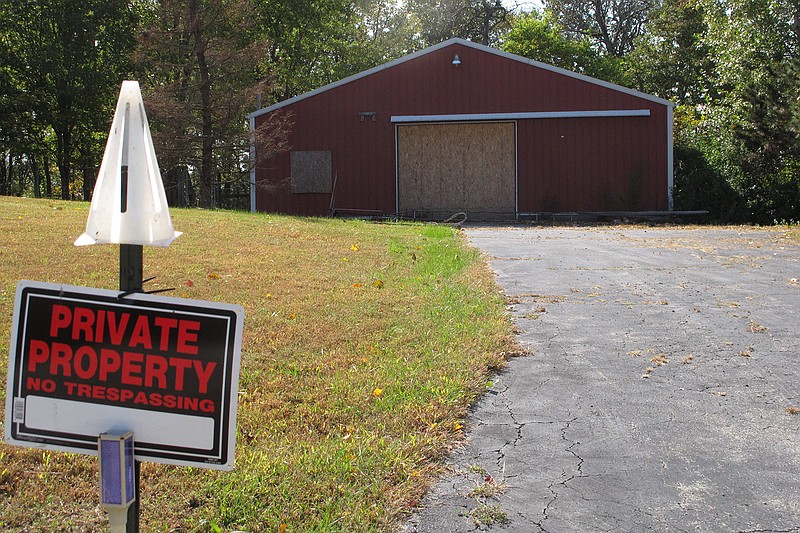 In this Tuesday, Oct. 18, 2016 photo, a private property sign guards the boarded up garage on property on Union Hill Road near the trailer where the bodies of Dana Rhoden and her children, Chris Rhoden Jr., and Hanna Rhoden, were found on April 22, three of eight family members found shot to death that day in a still-unsolved crime, in Piketon, Ohio. 