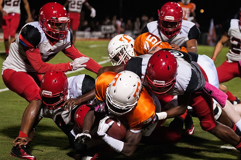 Texas High's Tevailance Hunt is taken down by a gang of Greenville defenders after earning yards after a reception Friday night during the second quarter in Texarkana, Texas. 