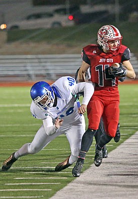 Jays receiver Adam Huff is forced out of bounds by Jake Roark of Blue Springs South during Friday night's Class 6 district game at Adkins Stadium.