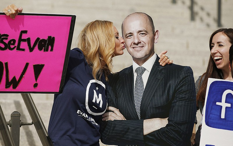 In this Oct. 13, 2016, file photo, Brynnley Pyne pretends to kiss a cardboard cutout of Evan McMullin as McMullin supporters rally at the Utah State Capitol in Salt Lake City. Two months after he jumped into the presidential race as a political unknown and fringe candidate, McMullin is surging in the polls in Utah and drawing large crowds at rallies as he becomes the conduit for conservative voters fed up with Republican Donald Trump's crudeness and antics. 