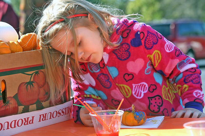 Arya Spencer, 7, paints a miniature pumpkin Saturday, Oct. 22, 2016 during the Centertown Baptist Church's first fall festival in Centertown. The festival featured games and prizes, a bounce house, a pumpkin painting station, a photo booth, face painting and live music.