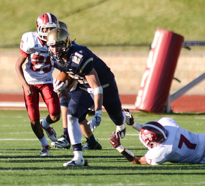 Helias Crusaders running back Jacob Storms slips his feet through the hands of a Warrensburg defender for a large gain on the ground during their first-round district football game in Jefferson City on Saturday, Oct. 22, 2016.  