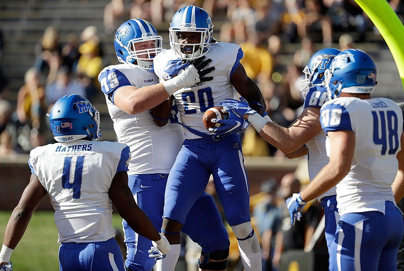 Middle Tennessee wide receiver Dennis Andrews (20) is congratulated by teammates after scoring during the first half of an NCAA college football game against Missouri, Saturday, Oct. 22, 2016, in Columbia, Mo. 