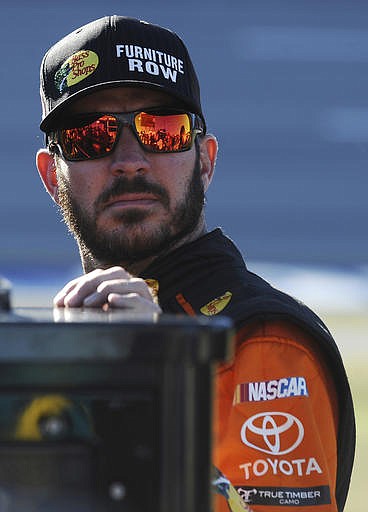 Martin Truex Jr. stands on pit road before qualifying for Sunday's NASCAR Sprint Cup auto race at Talladega Superspeedway on Saturday, Oct. 22, 2016, in Talladega, Ala. 