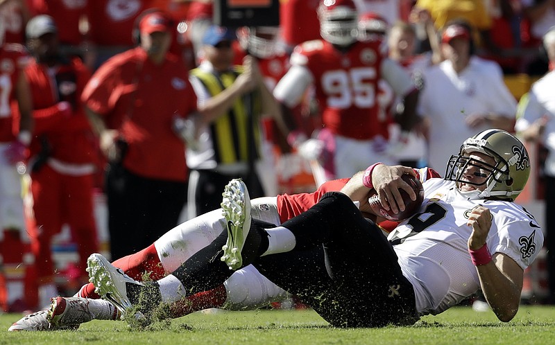 New Orleans Saints quarterback Drew Brees (9) lands after being sacked by Kansas City Chiefs defensive back Daniel Sorensen, rear, during the first half of an NFL football game in Kansas City, Mo., Sunday, Oct. 23, 2016.