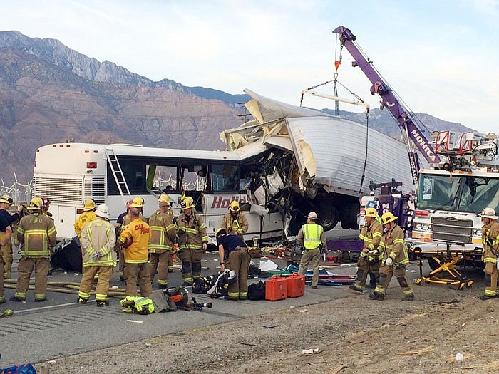 Emergency personnel work the scene where a tour bus crashed into the rear of a semi-truck on westbound Interstate 10, just north of the desert resort town of Palm Springs, in Desert Hot Springs, California.