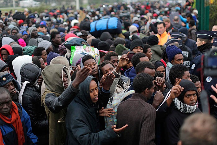 Migrants line-up to register Monday at a processing centre in the makeshift migrant camp known as "the jungle" near Calais, northern France.