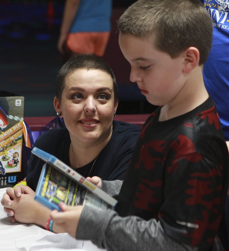 In an Oct. 3, 2015 photo, Jennifer Cooper, 34, looks at her son Devon during his 8th birthday party at Angelo Skate and Fun Center. Cooper has metastatic breast cancer and is now on in-home hospice care. Since her diagnosis, Jennifer Cooper has counted time by birthdays and holidays. 