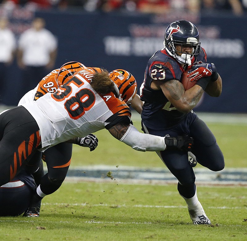 Then-Houston Texans running back Arian Foster escape s from the Cincinnati Bengals defense Jan. 5, 2013, during the second half of an AFC playoff  game in Houston. Foster says he will retire from the NFL.