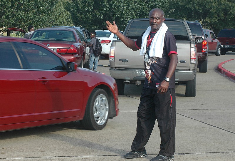 Liberty-Eylau Middle School coach Stasik Vaughn directs traffic Tuesday morning, Oct. 25, 2016, after school was dismissed because a water pipe broke.The pipe was repaired late Monday night, but another leak formed Tuesday morning, requiring the school with 720 students to close. Parents and guardians picked up the students while Vaughn helped to direct traffic in the school's parking lot.