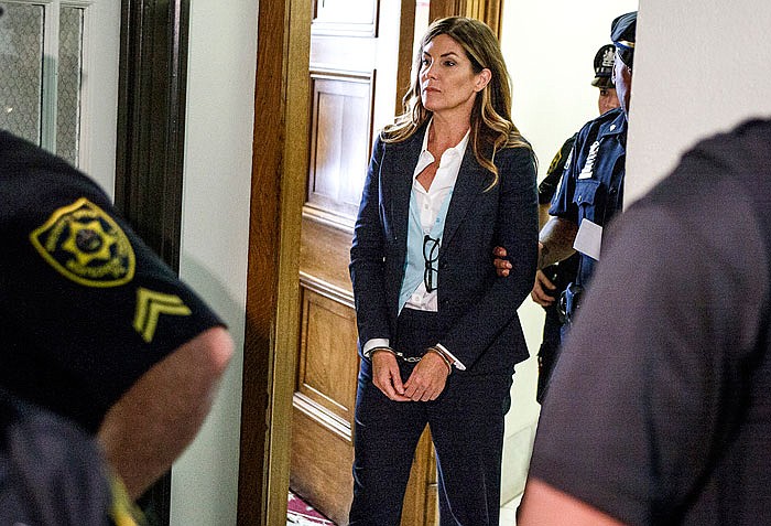 Former state Attorney General Kathleen Kane leaves court in handcuffs.
