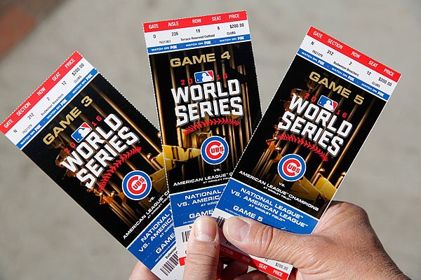 Cubs fan Robert Lyons, who lives in Los Angeles and was raised in Berwyn, Ill., shows his World Series tickets outside Wrigley Field on Monday in Chicago.