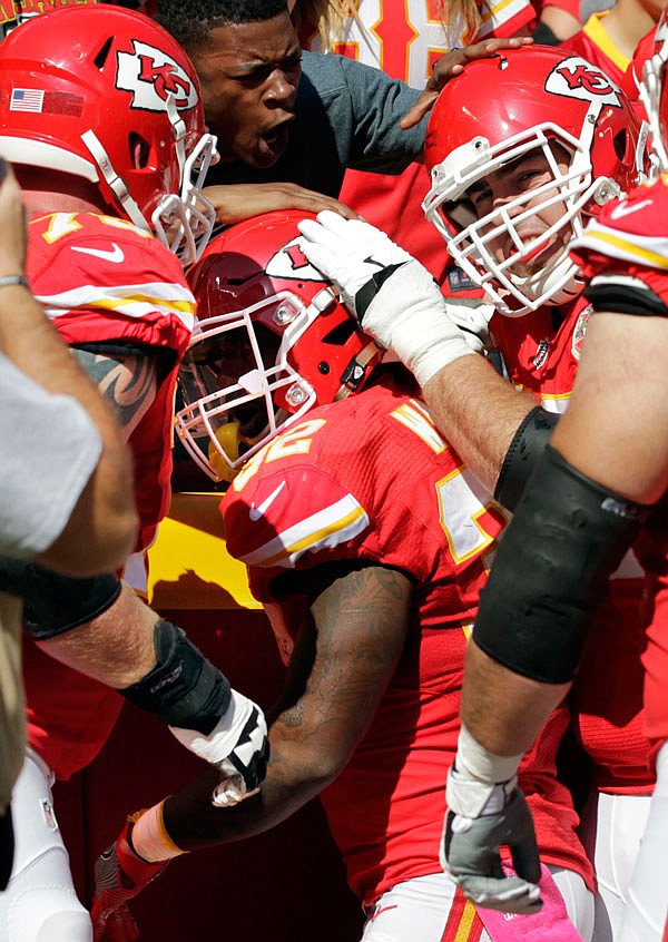Spencer Ware (center) celebrates with Chiefs teammates and fans after he scored a touchdown during Sunday's game against the Saints at Arrowhead Stadium.