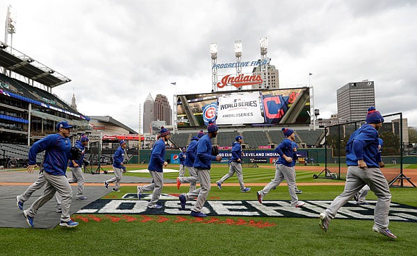 Cubs players warm up during a team practice Monday in Cleveland in preparation for the start of the World Series, which begins tonight.
