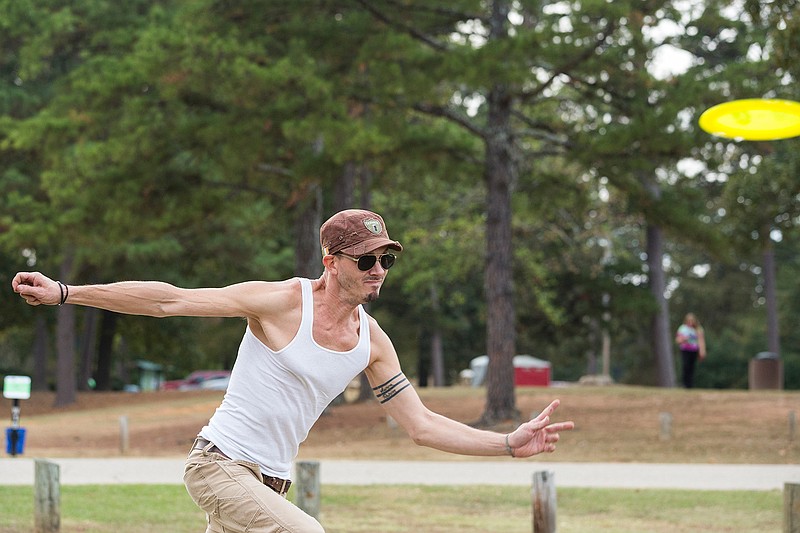 Sky Robertson throws a disc Tuesday at Spring Lake Park. He and his friends are seasoned players, and they took the opportunity to teach disc golf to another friend Tuesday afternoon. 