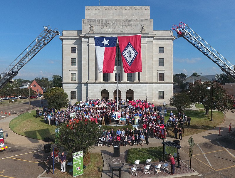 More than 300 locals pose for a group photo Tuesday morning on the state line of Texas and Arkansas at the Downtown Post Office during the ceremony for Texarkana being designated a Cultural District by the Texas Commission on the Arts. 