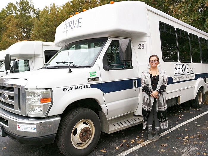 Courtney Harrison, transportation director for SERVE Inc., poses with one of the TRAN vehicles.