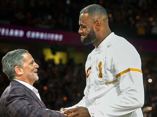 LeBron James accepts his NBA championship ring from Cavaliers owner Dan Gilbert before Tuesday night's game against the Knicks in Cleveland.