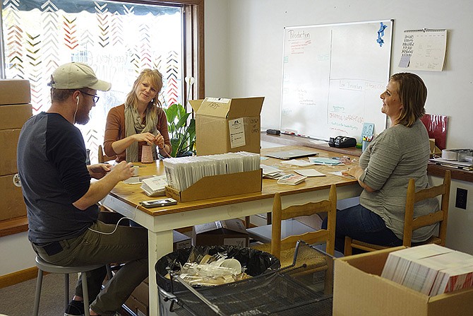 1Canoe2 employees, from left, Luke Wilson, Liz Goebel and Kim Linnenbringer, prepare cards for shipping. The business is set to have a grand opening Nov. 11 during downtown Fulton's Holiday Open House.