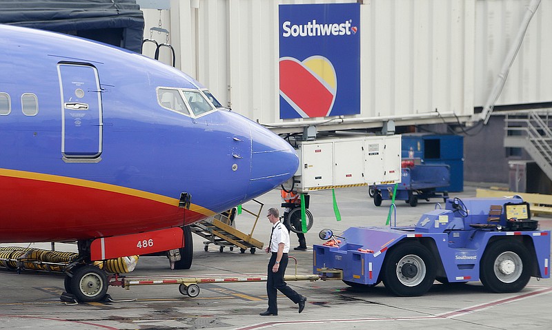 In this Monday, May 9, 2016, photo, a Southwest Airlines pilot performs a preflight check on an aircraft at HartsfieldJackson Atlanta International Airport, in Atlanta. Southwest Airlines reports financial results Wednesday, Oct. 26, 2016.