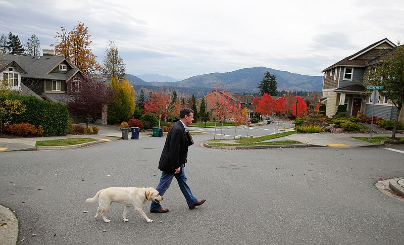 In this photo taken Oct. 24, 2016, Sen. Mark Mullet, D-Issaquah, walks with his dog Arthur as he rings doorbells of registered voters in Issaquah, Wash. Mullet is being challenged for his seat in the state legislature by State Rep. Chad Magendanz, R-Issaquah. 