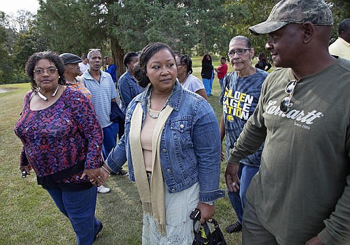 Stacey Payton, center, and Hollis Payton, right, the parents of a high school student, walk with supporters, in front of the Stone County Courthouse in Wiggins, Miss., Monday, Oct. 24, 2016. Mississippi NAACP president Derrick Johnson is demanding a federal investigation after the parents said four white students put a noose around their son's neck at school.