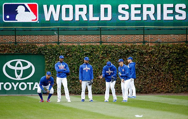 Cubs players work out in the outfield Thursday during batting practice for today's Game 3 of the World Series against the Indians in Chicago.