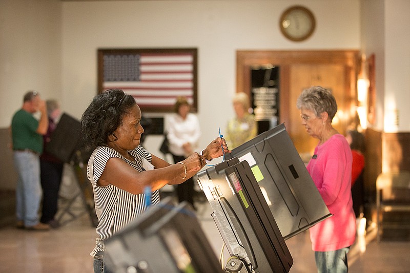 Miller County elections official Bernice Harvey locks an electronic voting machine as Elections Coordinator Linda Crawford shuts another one down at the end of the day Thursday at the Miller County Courthouse. During early voting, Crawford has to be the first one in and the last one to leave to ensure security measures are followed.