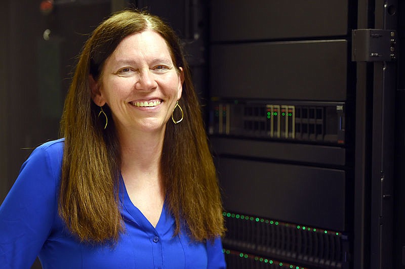 Elizabeth Huber stands in front of her IBM machines at Huber & Associates. Huber formerly worked at IBM before founding Huber & Associates.