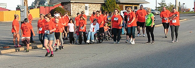 The participants in the Multiple Sclerosis (MS) Fun Walk, Run, or Roll event start down Bowling Street in California next to Village Green shopping Center.