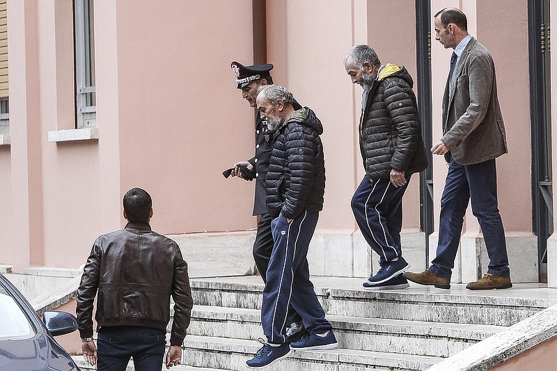 The two Italian hostages that were freed in Libya, Bruno Cacace, second from left, and Danilo Calonego, second from right, leave a police station after being questioned by prosecutor Sergio Colaiocco, in Rome, Saturday, Nov. 5, 2016. The two had been kidnapped at Gath, Libya, on Sept. 19.