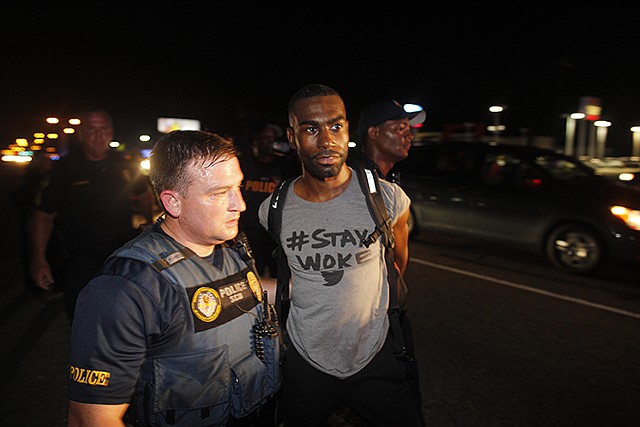 Police officer arrests DeRay Mckesson for blocking Airline Highway on July 9 during a protest in Baton Rouge, Louisiana. A Baton Rouge police officer who claims he was injured Monday during the protest after a deadly police shooting filed a lawsuit against prominent Black Lives Matter activist Mckesson.