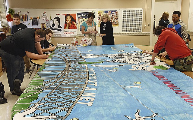 Students in Jennifer Milne's class at Jefferson City Academic Center spent their class time Wednesday working on the 8 feet by 20 feet vinyl mural. The theme is "Taking drugs is like walking a tightrope without a net" and aimed at making students think twice before using drugs. The Council for Drug Free Youth is partnering with schools so students can take ownership of the project and be educated about their choices. In the background middle are Joyce Neuenswander, left, and Lucia Erikson-Kincheloe, artists working with the students to bring the large panel to its colorful fruition.