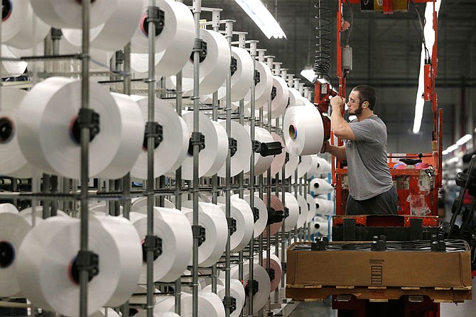A worker loads spools of thread last month at the Repreve Bottle Processing Center, part of the Unifi textile company, in Yadkinville, North Carolina. America has lost more than 7 million factory jobs since manufacturing employment peaked in 1979. 