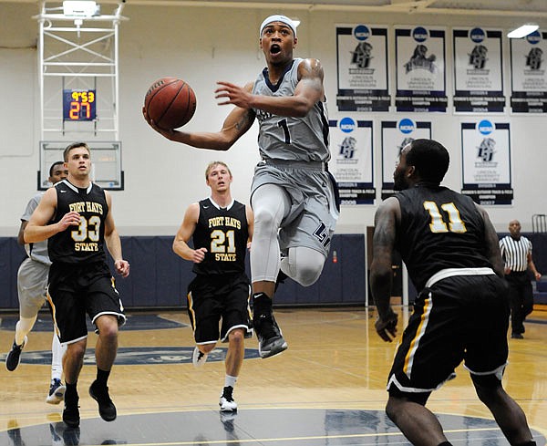 Lincoln guard Anthony Virdure goes up and around Fort Hays State guard Rob Davis and scoops in the layup during a game last season at Jason Gym.