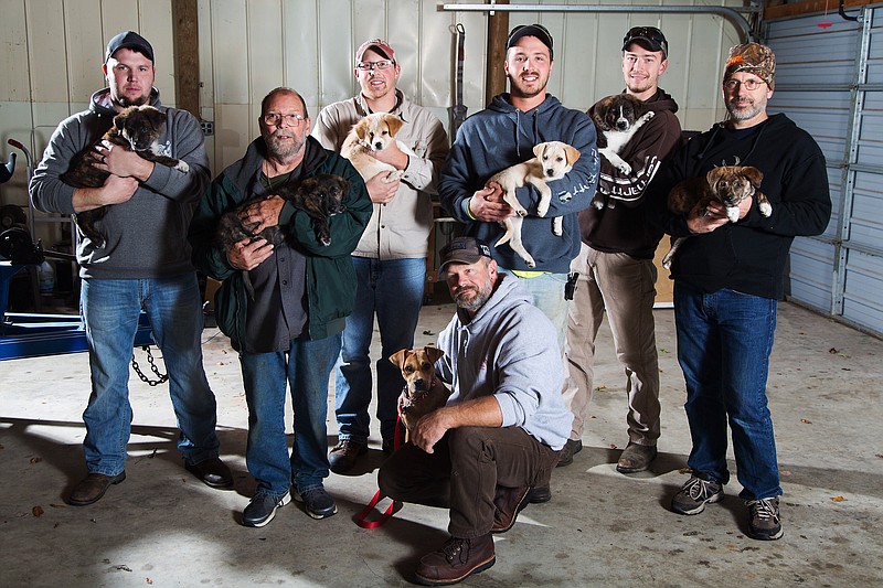 In this Wednesday, Oct. 26, 2016 photo, from left, Jake Rowe holding Knox, Joe Gruber holding Bear, Alex Manchester holding Rosie, Doug Craddock with Annie, Mitchel Craddock holding Brimmie, Brent Witters holding Finn and Dexter Jennings holding Gunner pose for a photo in Vicksburg, Mich. It all started the morning of Mitchel Craddock's 5-day bachelor getaway, a four-wheeling trip to Tennessee arranged by the Best Man in Craddock's Oct. 8 wedding. Friends of Mitchel Craddock, the bridegroom-to-be, each came home from his bash with a puppy.