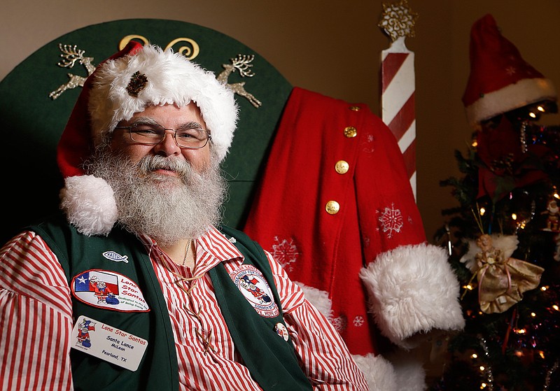 Lance McLean poses along with his Santa Claus coat at his home Thursday, Oct. 27, 2016, in Pearland, Texas.  McLean works as a professional Santa Claus during the holidays.