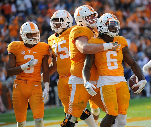 Teammates celebrate with Tennessee running back Alvin Kamara (right) after he scores a touchdown against Kentucky during the second half of Saturday's game at Neyland Stadium in Knoxville, Tenn.