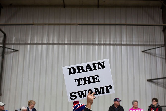 Supporters of then-Republican presidential candidate Donald Trump hold signs during an Oct. 27 campaign rally in Springfield, Ohio. President-elect Trump's campaign promise to "drain the swamp" of Washington might make it difficult for him to fill all the jobs in his administration.