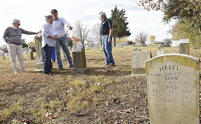 Jeanne Rutledge, left, inspects a headstone as Nancy Thompson and Tim Theroff discuss the location of another stone. Donald Beck, background right, watches as other members of Jefferson City's Cemetery Resources Board walk through and observe markers in Longview Cemetery after Thursday's meeting.