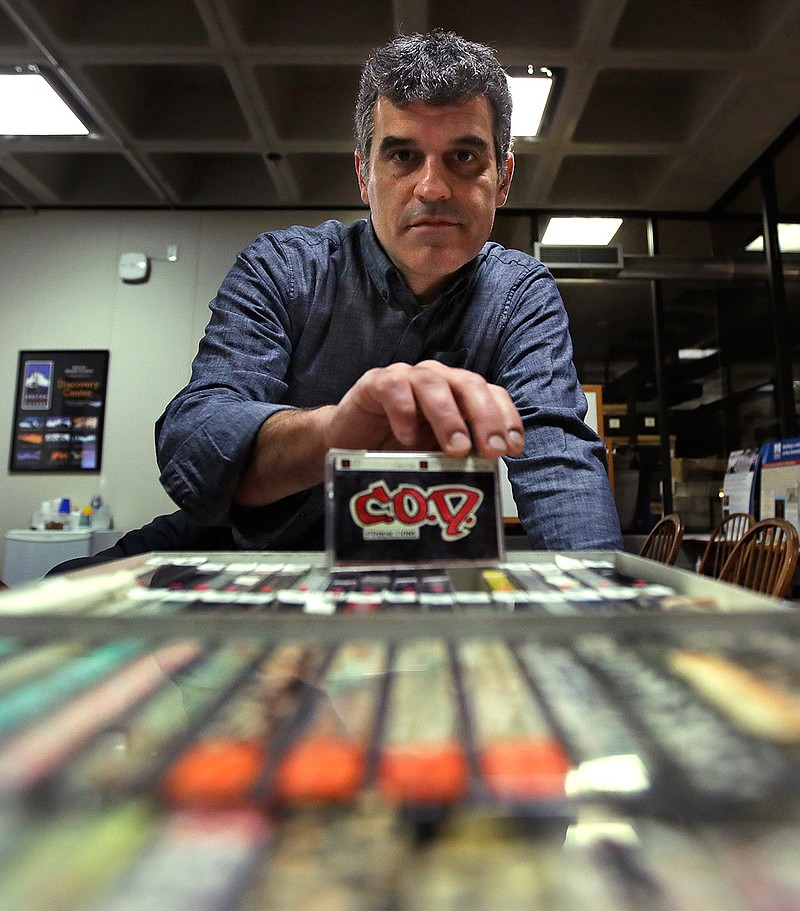 Pacey Foster, a rap historian and professor at UMass, holds up a recording of the musical group COD as he poses with a collection of hip-hop cassette tapes from the 1980's at the Boston campus of the University of Massachusetts in Boston, Thursday, Nov. 17, 2016. Thanks to UMass, the world will soon have access to 300 unreleased demo tapes from the early days of Boston hip-hop. The university paired with Boston Public Library to form a new hip-hop archive that's the latest example of colleges treating hip-hop as a scholarly subject. 