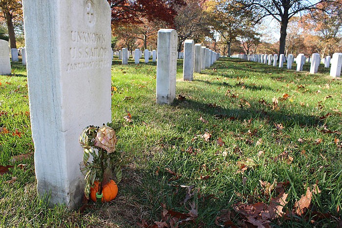 a gravestone, left, with the inscription UNKNOWN U.S. SAILOR, is adorned with a flower and a small pumpkin at Long Island National Cemetery in Farmingdale, N.Y. A WWII researcher says he has documents showing the grave is one of four that each holds the body of a sailor who perished on Jan. 3, 1944, when their ship, the USS Turner, exploded and sank at the entrance to New York Harbor. That researcher believes many more victims of the disaster were buried in the graves together. The Pentagon still lists 136 sailors from the disaster as missing.