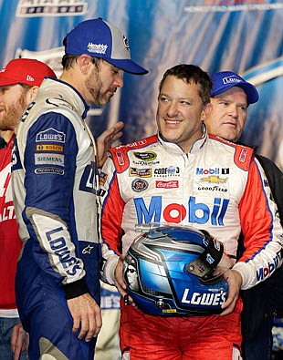 Tony Stewart smiles as he holds the helmet given to him Sunday as a gift by Jimmie Johnson after the race in Homestead, Fla.