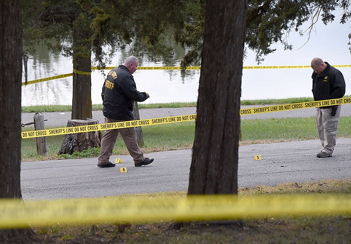 Above, members of the Cole County Sheriff's Department examine the crime scene of a shooting at County Park on Monday. A woman was shot in the arm and transported to University in Columbia. 